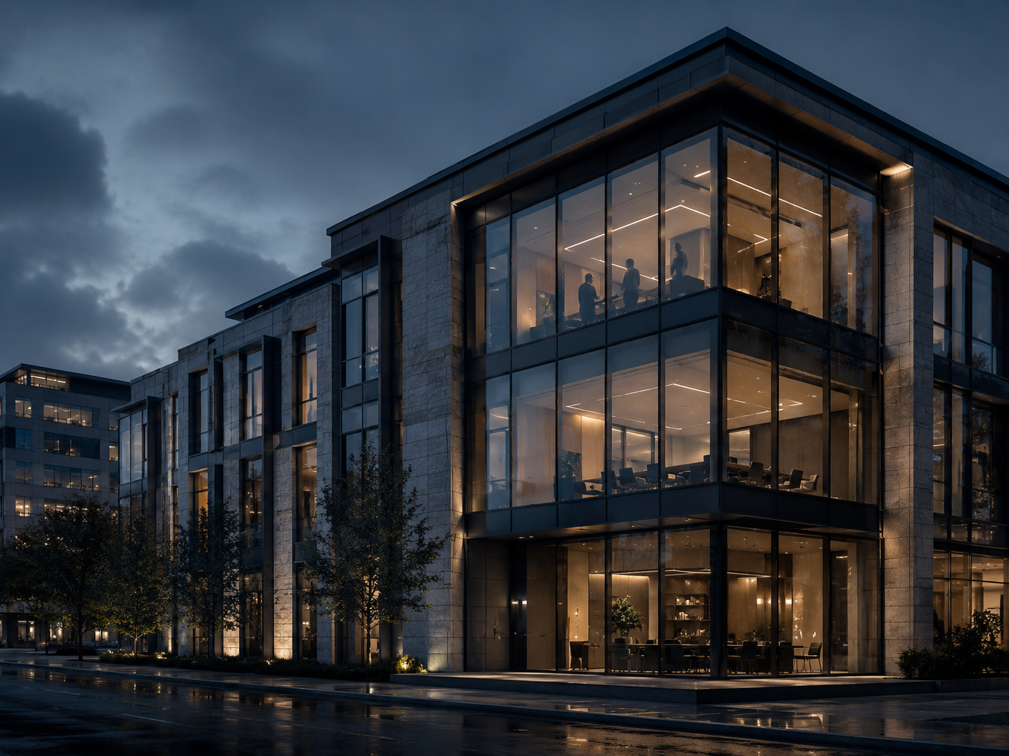 Modern commercial building at dusk with lit conference rooms.